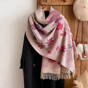 Detail view of floral beige scarf with elegant red flower patterns and hanging tassels