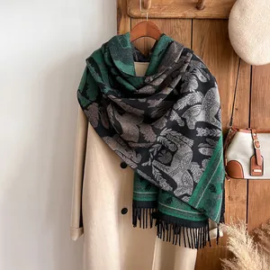 Detail of vintage jacquard scarf with horse motifs and fine black fringe tassels