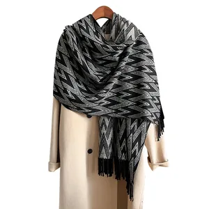 Winter geometric pattern pashmina scarf with long tassels displayed on a coat