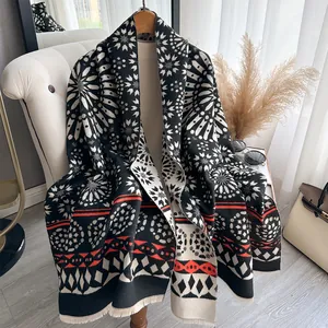 Ethnic cashmere feel shawl with geometric patterns and tassels on a wooden hanger