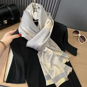 Close-up of silver and gold paisley pashmina shawl with elegant fringe and silky texture