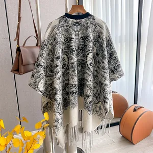 Détail de poncho en tricot avec motifs totems vintage et finitions à franges denses