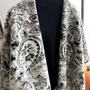 Détail d'un châle en maille épaisse avec des motifs paisley vintage noir et blanc