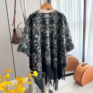 Détail d'un châle en maille avec motif paisley noir et blanc et ourlet à franges