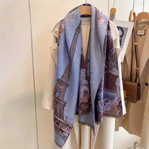 Detailed close-up of cashmere scarf featuring blue landscape print and delicate fringes