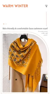 Dettaglio di sciarpa gialla effetto cashmere con ricamo floreale colorato e frange