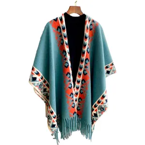 Ethnic style knitted shawl cape with fringe and geometric patterns in turquoise and navy