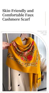 Detail of floral embroidery and fringe on a soft cashmere-feel yellow scarf