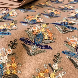 Dettaglio del ricamo floreale ad alta densità su una calda sciarpa in stile vintage