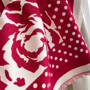 Detail of red rose floral and polka dot pattern on thick cashmere-like square shawl