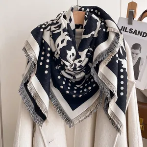 Detailed texture of thick cashmere-feel scarf with elegant polka dots and fringes