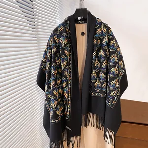Dettaglio del ricamo floreale e frange nere su una calda sciarpa di cashmere elegante