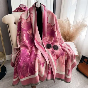 Detail of pink floral cashmere scarf featuring camellia patterns and delicate fringe trim