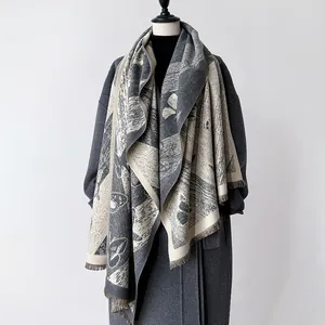 Détail d'un châle gris en cachemire avec motif papillon jacquard et bords à franges