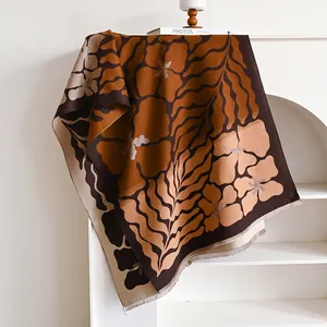 Detail of floral patterned pashmina shawl with caramel leaf design and tassel fringe edge