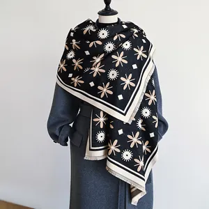 Detail of cashmere-feel scarf featuring beige floral geometric patterns and fringe edges
