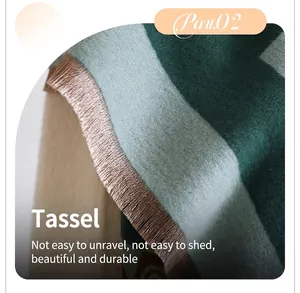 Gros plan sur la texture d'une écharpe en maille épaisse avec franges et rayures