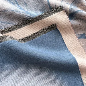 Dettaglio del tessuto jacquard in cashmere con motivi a foglie e frange bicolori