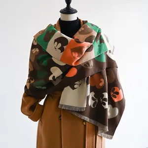 Detail of color-block knit scarf with heart petals and fringe on a mannequin