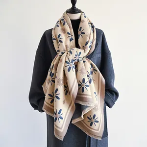 Elegant apricot cashmere-feel scarf with blue floral patterns and tassel fringe details