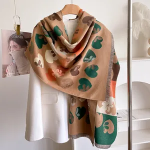 Detail view of heart and flower jacquard knit scarf with fringe edge for autumn and winter