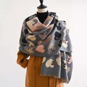 Detail of soft heart pattern scarf with fringe edges draped on a stylish coat