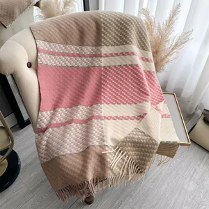 Detail of soft cashmere-like scarf with plaid pattern, tassels and thick knit texture
