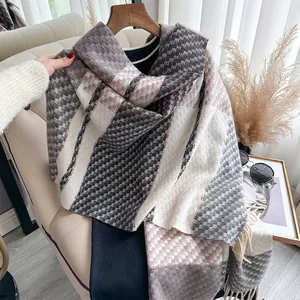 Detail of soft cashmere-feel scarf with vintage houndstooth pattern and fringe trim