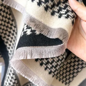 Detail of black and white houndstooth scarf with soft grey tassel fringe textures