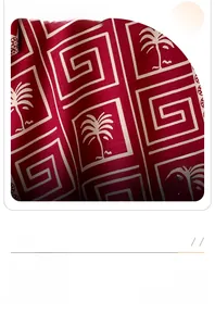 Detail of red cashmere-feel scarf with palm tree patterns and vintage geometric borders