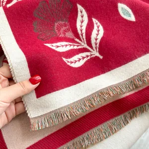 Detailed macro view of red floral pashmina scarf with jacquard patterns and soft fringes