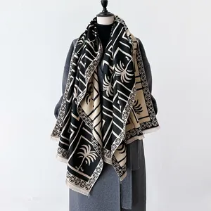 Close-up of palm tree pattern and fringe on a thick double-sided cashmere-like shawl
