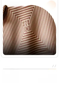Detail view of brown cashmere shawl showing geometric maze pattern and soft fiber texture