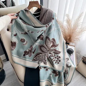 Detail of a thick cashmere-style scarf with pomegranate jacquard and tassel edges