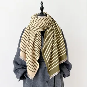 Detail of dark green and beige striped cashmere shawl with elegant fringe edges