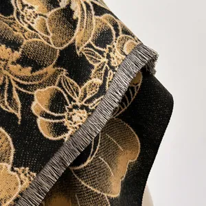 Nahaufnahme von Jacquard-Schal in Schwarz und Gold mit Blumenmuster und weichen Fransen