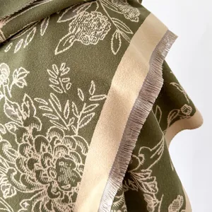 Detailed view of olive green floral jacquard scarf fabric with elegant beige tassels