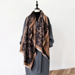 Detailed view of floral jacquard texture and fringed edges on the cashmere shawl
