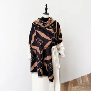 Close-up of brown and khaki geometric cashmere-feel scarf with tassels on a mannequin