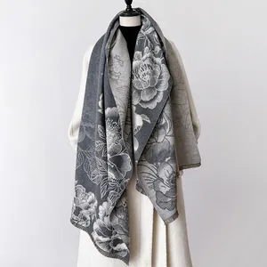 Detail eines grauen Blumendesigns und Fransen am Pashmina-Schal mit Jacquard-Muster