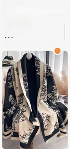 Detail of cashmere-like scarf with bamboo print, color-blocking design and tassel edges