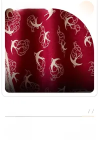 Detailed close-up of cashmere-like scarf with red swallow and classical cloud patterns