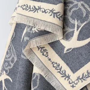 Close-up of cashmere-like scarf showing flying bird jacquard pattern and fringe details