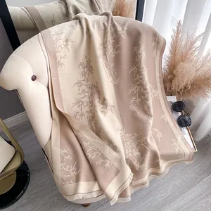 Detailed view of bamboo print shawl with fringe on cozy beige cashmere-like fabric