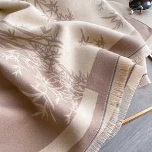 Detailed view of the soft cashmere-feel fabric featuring bamboo leaf prints and fringe tassels