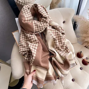 Detailed close-up of thick houndstooth scarf with soft fringe and warm autumn textures