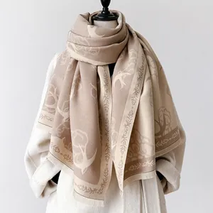 Close-up of beige cashmere scarf with swallow and floral jacquard patterns