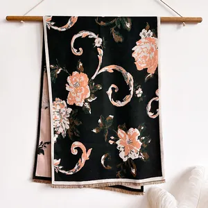 Detail of vintage floral pattern and beige tassels on soft black pashmina shawl