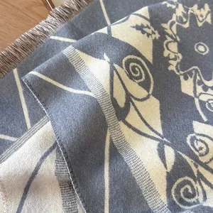 Elegante grijze en crème gebreide sjaal met kwastjes en geometrisch jacquardpatroon
