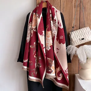 Detailed view of burgundy cashmere-like scarf with vintage floral patterns and fringe